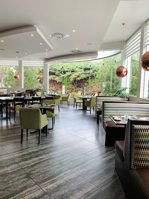 Enjoy meals in a spacious dining area with tables, booths, and comfortable seating.