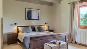 A bedroom with a wooden bed, two bedside tables, a nightstand, a painting on the wall, and a window with curtains. - Awesome home in Pazin (Pazin)