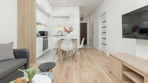 Un appartement moderne comprenant une cuisine, un coin repas et un espace de vie.