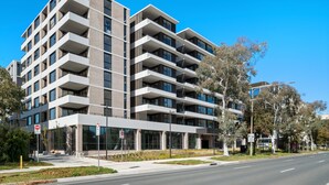 Un immeuble à plusieurs étages doté d’une architecture moderne, avec des balcons et de grandes fenêtres.