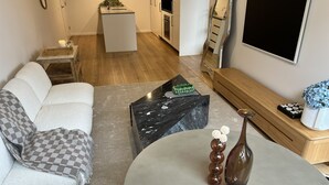 Un salon moderne avec un canapé, une table basse et un téléviseur.