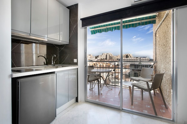 Une cuisine donnant sur un balcon et offrant une vue sur la ville.