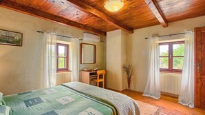 A bedroom with a bed, a desk, a chair, a mirror, and a window with curtains. - Gorgeous home in Svetvincenat with WiFi (Svetvincenat)
