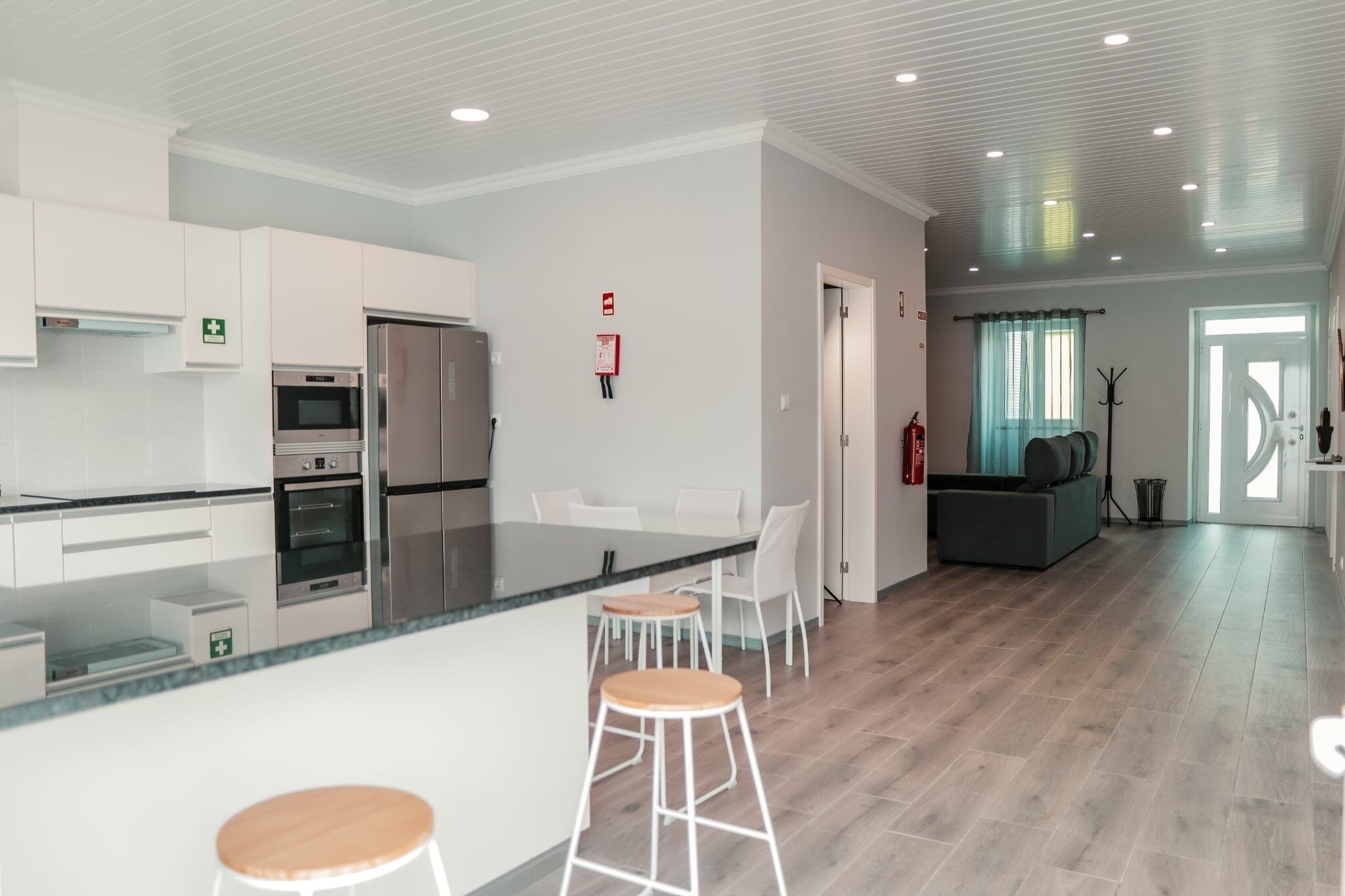 A modern kitchen with white cabinets, stainless steel appliances, and a central island with stools.