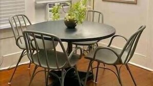 A round dining table with six chairs, a potted plant, and a modern light fixture above. - 4BR Downtown Lafayette-Garden, Parking, Walk to Arts District (Lafayette)