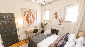 A bedroom with a bed, bedside table, lamp, and artwork on the wall. - Modern Art-Deco – Steps from Downtown Lafayette (Lafayette)