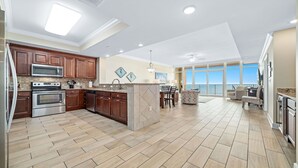 A spacious kitchen with modern appliances, a dining area with a view, and a cozy seating area. - Beachfront 3BR with water slide!  New to the Rental Market!! (Gulf Shores)
