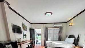 Une chambre d’hôtel avec deux lits, un bureau, une télévision et un appareil de climatisation.
