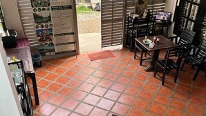 Un hall d’hôtel avec un sol carrelé, un comptoir d’accueil et un escalier.
