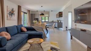 Una sala de estar moderna con un sofá, una mesa de centro y un comedor con sillas y una mesa.