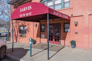 A building with a red awning labeled "Jarvis Condos" at 125 W 10 ST.