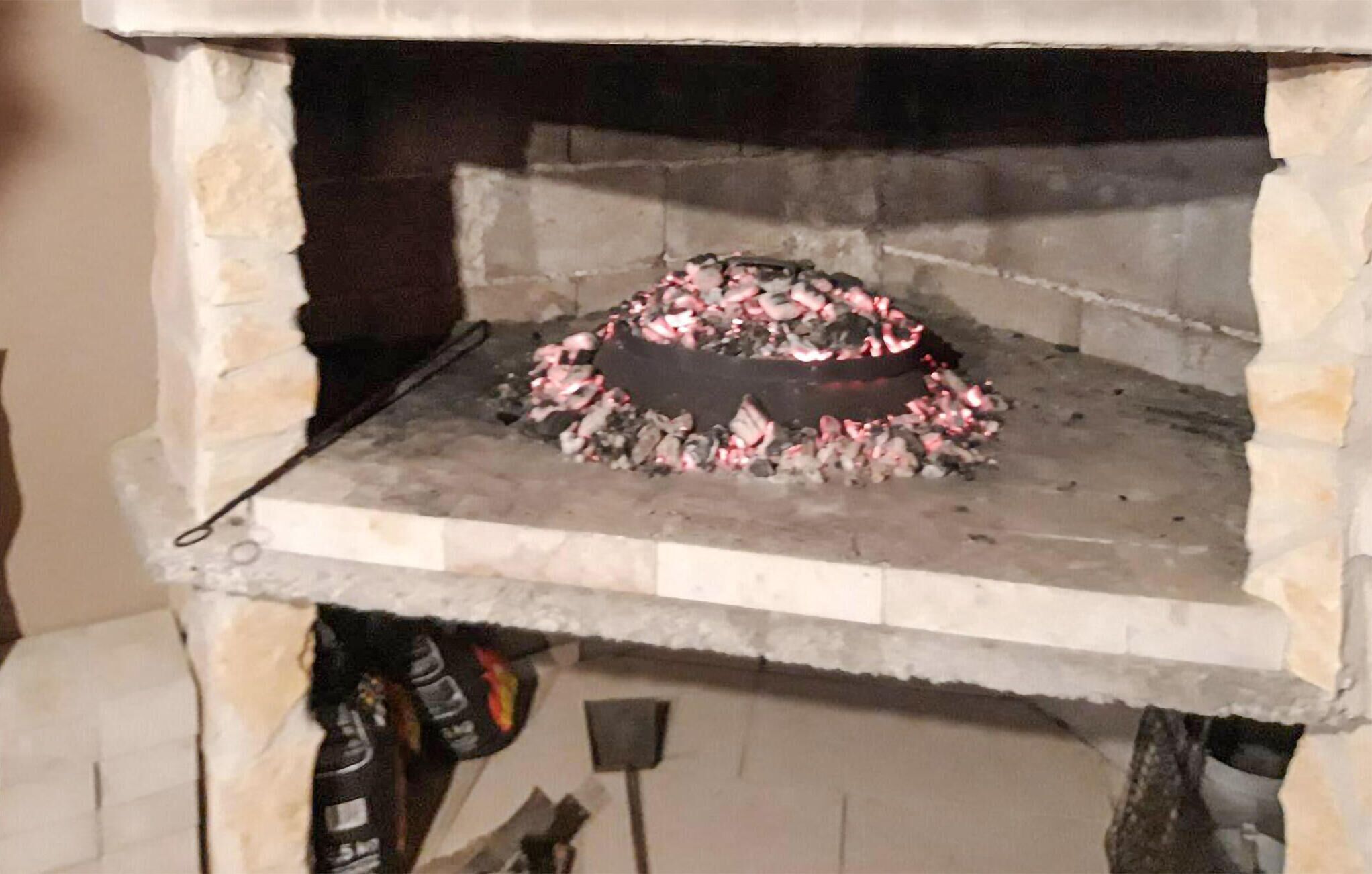 Kivestä rakennettu pizzauuni, jonka sisällä palaa tuli.