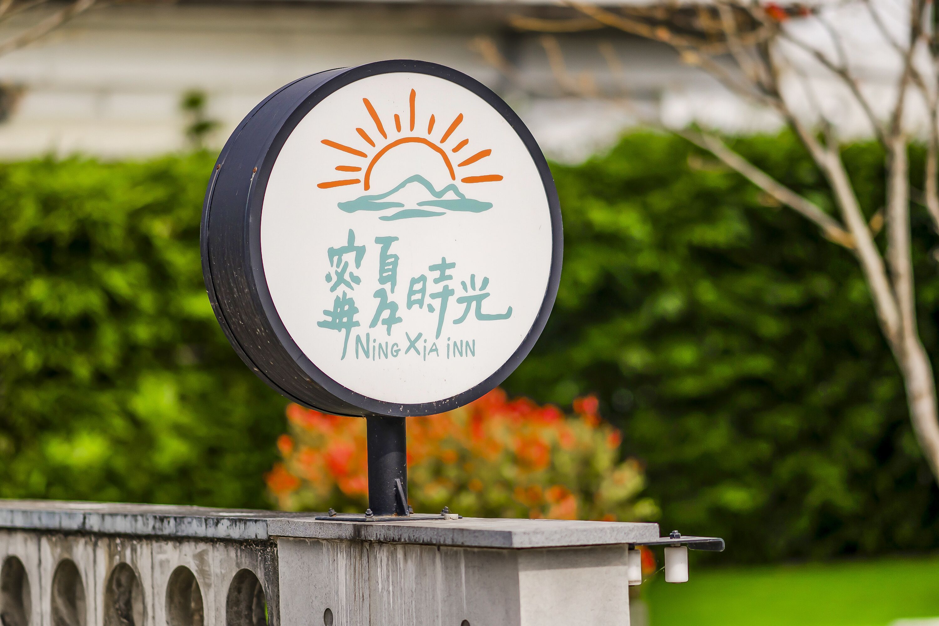A sign for Ningxia Inn with a sun and mountain design.
