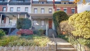 A row of townhouses with a stone wall in the foreground, a front porch, and a small garden area. - 2 Mi to National Mall: Modern DC Home (Washington)