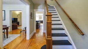 A staircase with wooden balusters and black steps leading to an upper floor. - 2 Mi to National Mall: Modern DC Home (Washington)