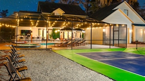 A house with a swimming pool, outdoor seating, and string lights. - Valrico Villa: Pool, Spa, Court & Game Room (Brandon)