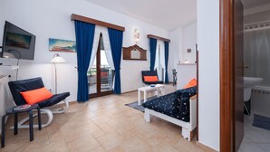 Une chambre d’hôtel avec un lit, une chaise, un bureau, une télévision et une salle de bain.
