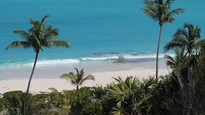 A beach with palm trees and clear blue water. - Sky Beach Club Villa Waterfall 2 4 Bedroom Home (Governor's Harbour)