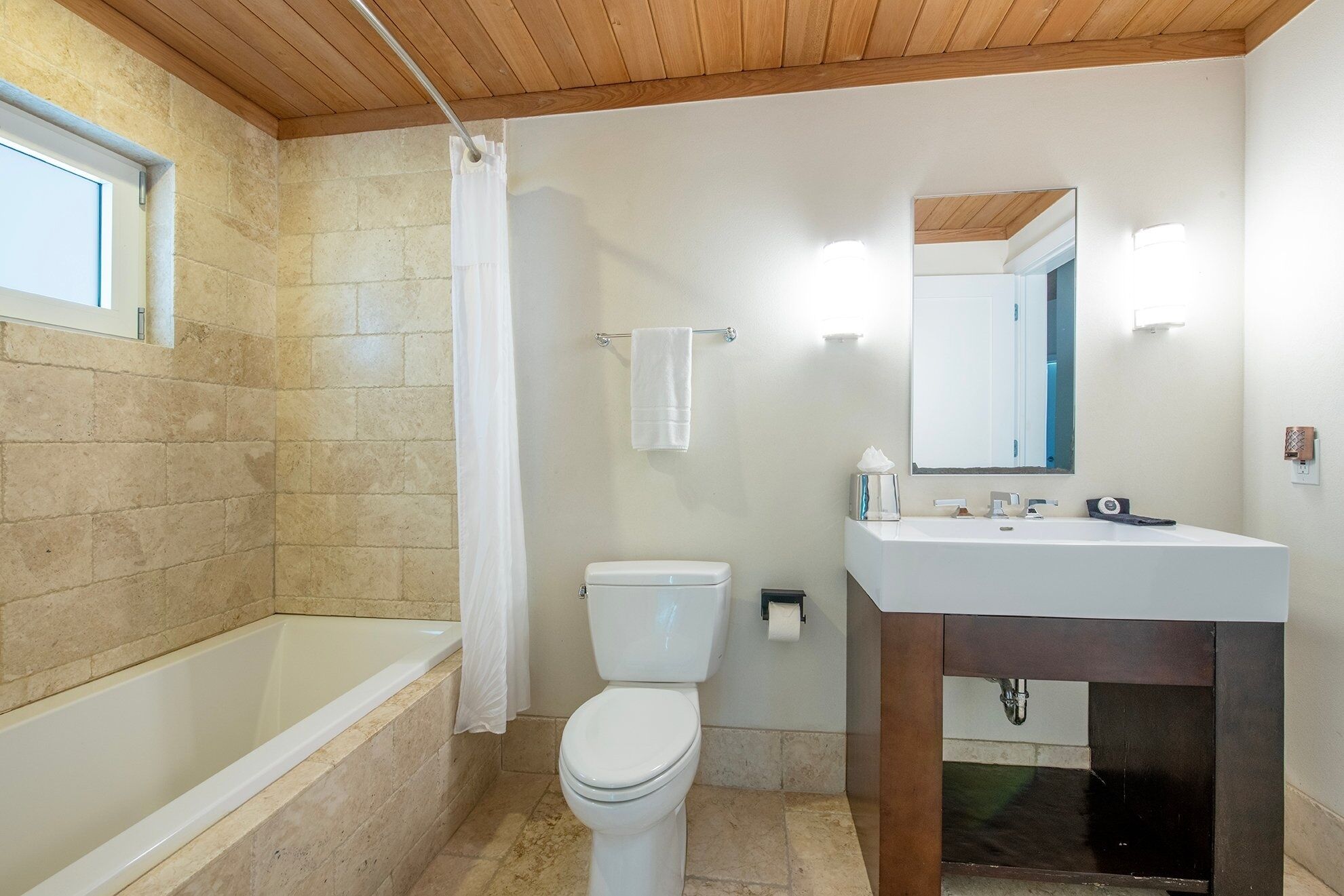 A bathroom with a bathtub, toilet, and sink.