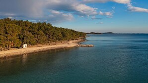 A coastal area with a beach, a forested hillside, and a clear sky. - Villa Barbara Pakostane (Pakostane)