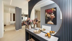A modern interior with a curved mirror, a floral arrangement, and a framed artwork on the wall. - Villa Barbara Pakostane (Pakostane)