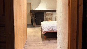 Un pasillo estrecho con paredes de madera y una cama a lo lejos.