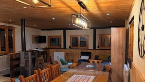 Un interior de madera con una larga mesa de comedor, sillas y una chimenea.