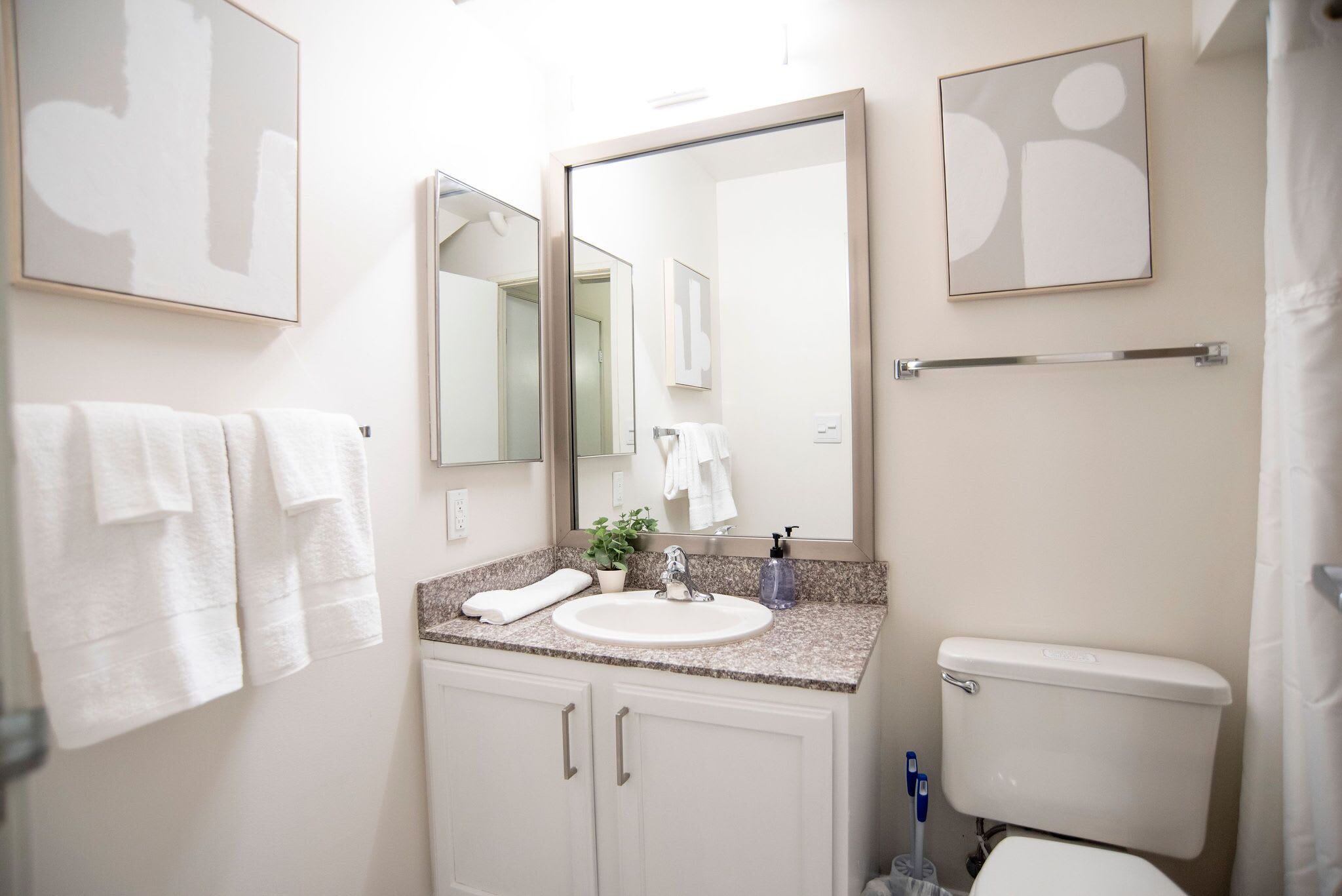 A bathroom with a sink, mirror, toilet, and towel rack.