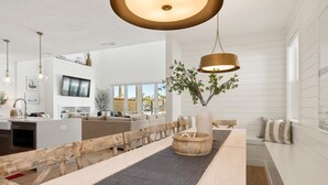 A modern kitchen with white cabinetry, a built-in oven, and a large island with a sink. - Experience Utah at the Beach: Desert Color Lagoon + Beaches (St. George)