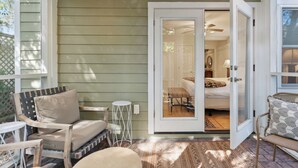 A cozy room with a bed, a chair, and a small table.