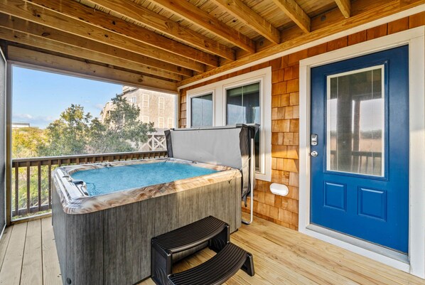 Relax in the 5-person hot tub on the first level's screened-in porch.