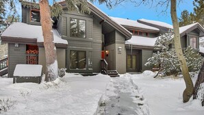 A two-story house with a covered driveway and snow on the roof.