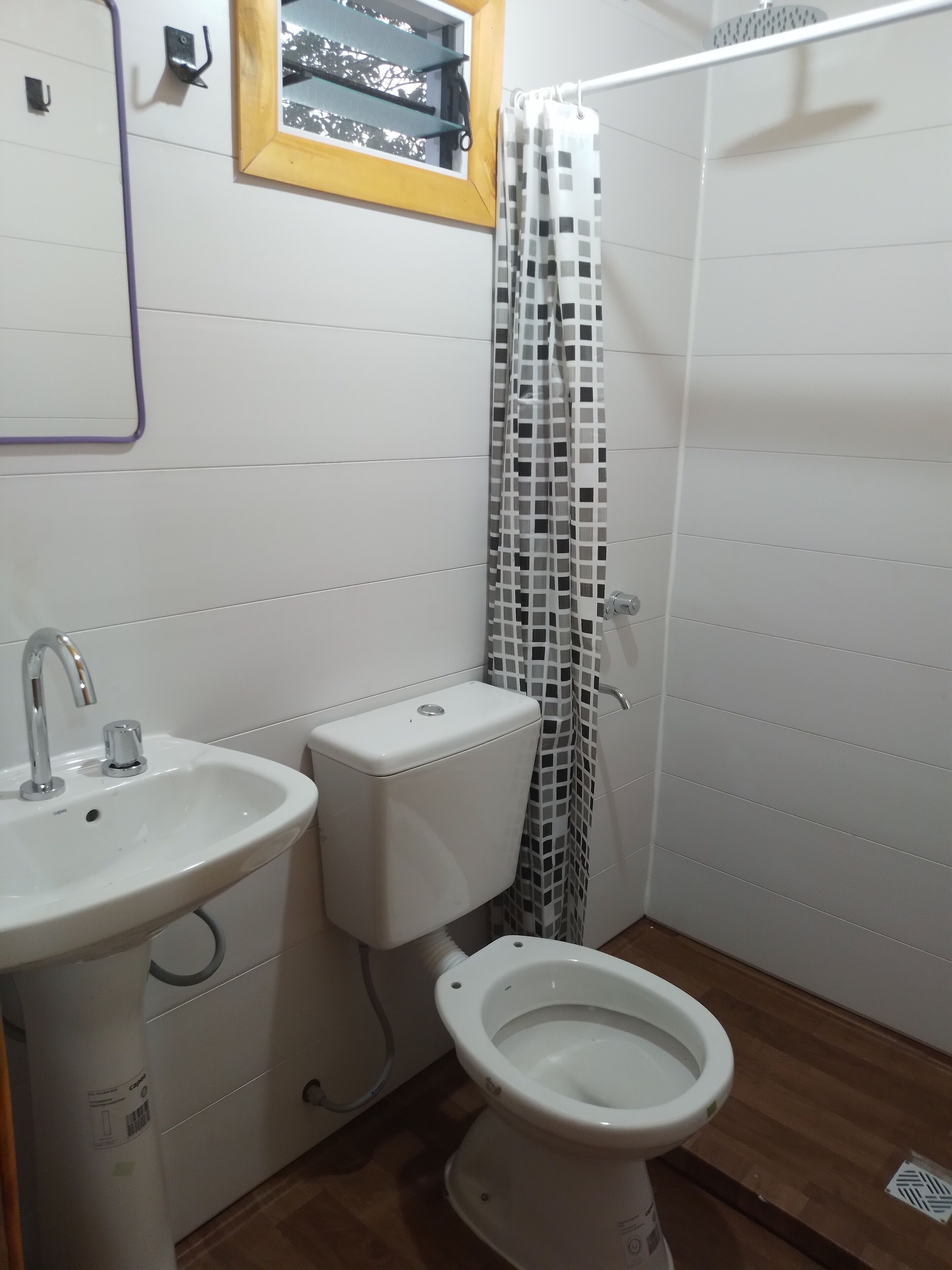 A bathroom with a white sink, toilet, and shower curtain.
