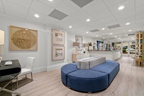 Relax and work in style in this modern space, featuring a comfortable seating area, reception desk, and elegant artwork.