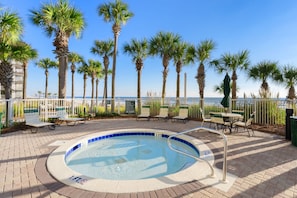 Relax by the oceanfront pool surrounded by palm trees and lounge chairs.