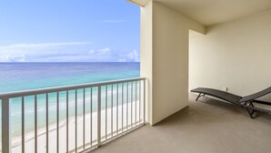 Un balcon avec vue sur une plage et l’océan.