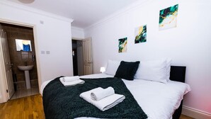 Ein Hotelzimmer mit Bett, Bad und Wandbildern.