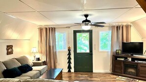 Un salon avec un canapé, une table basse, un téléviseur et un sapin de Noël.