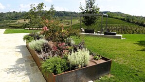 A garden with a variety of plants and a pergola with seating. - Luxury home with pool and spectecular views (Piemonte)