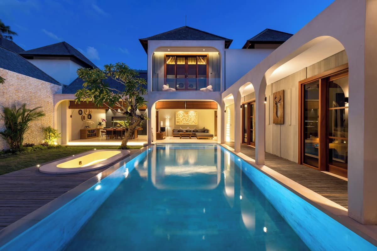 A modern house with a swimming pool, a dining area, and a large living room with a fireplace.