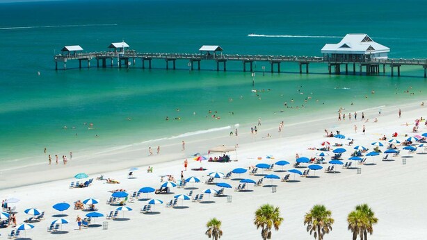 A beach with a pier and beach umbrellas. - Avalon. Fully renovated 2024. Pool view (Clearwater)