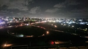 A nighttime cityscape with illuminated buildings and a circular park area. - Chic Studio in The Signature, Accra (Accra)
