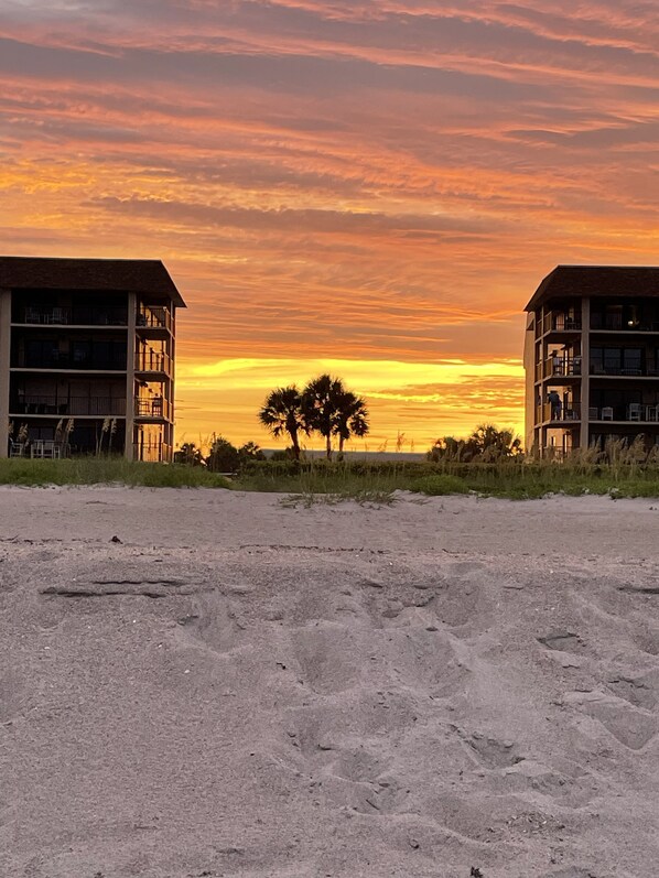 A beachfront hotel with a view of the sunset.