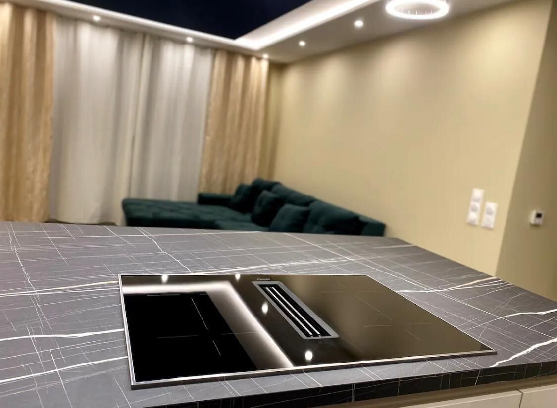A modern kitchen with a sleek black countertop and integrated stove.