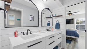 A modern bathroom with a double sink, vanity, and a large mirror. - Peacock Paradise in Ocala (Ocala)