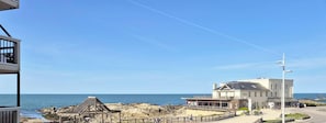 Un hotel frente al mar con vistas al océano, una costa rocosa y una estructura de madera.