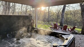 A hot tub with a view of a forest and outdoor seating area. - Secret Room-Hot Tub-Billards-Firepit-Games-Pool access (Gal)
