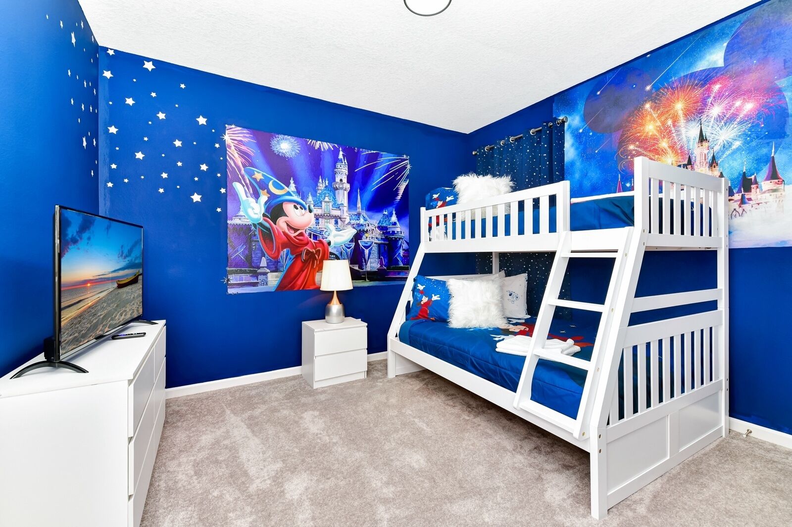 A child's bedroom with a bunk bed, a TV, a nightstand, and a mural of a castle.
