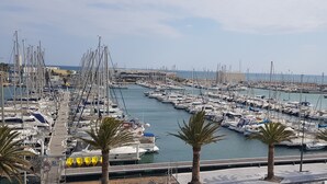 A marina with numerous boats docked, palm trees lining the waterfront, and a clear view of the sea. - Vue Exceptionelle ! Mer-port- Esplanade Oniria ! (Canet-en-Roussillon)