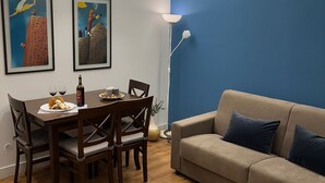 A dining area with a wooden table, chairs, and a blue accent wall. - GeLiRò Apartment Catania Centro - Comfort, style and perfect location (Catania)
